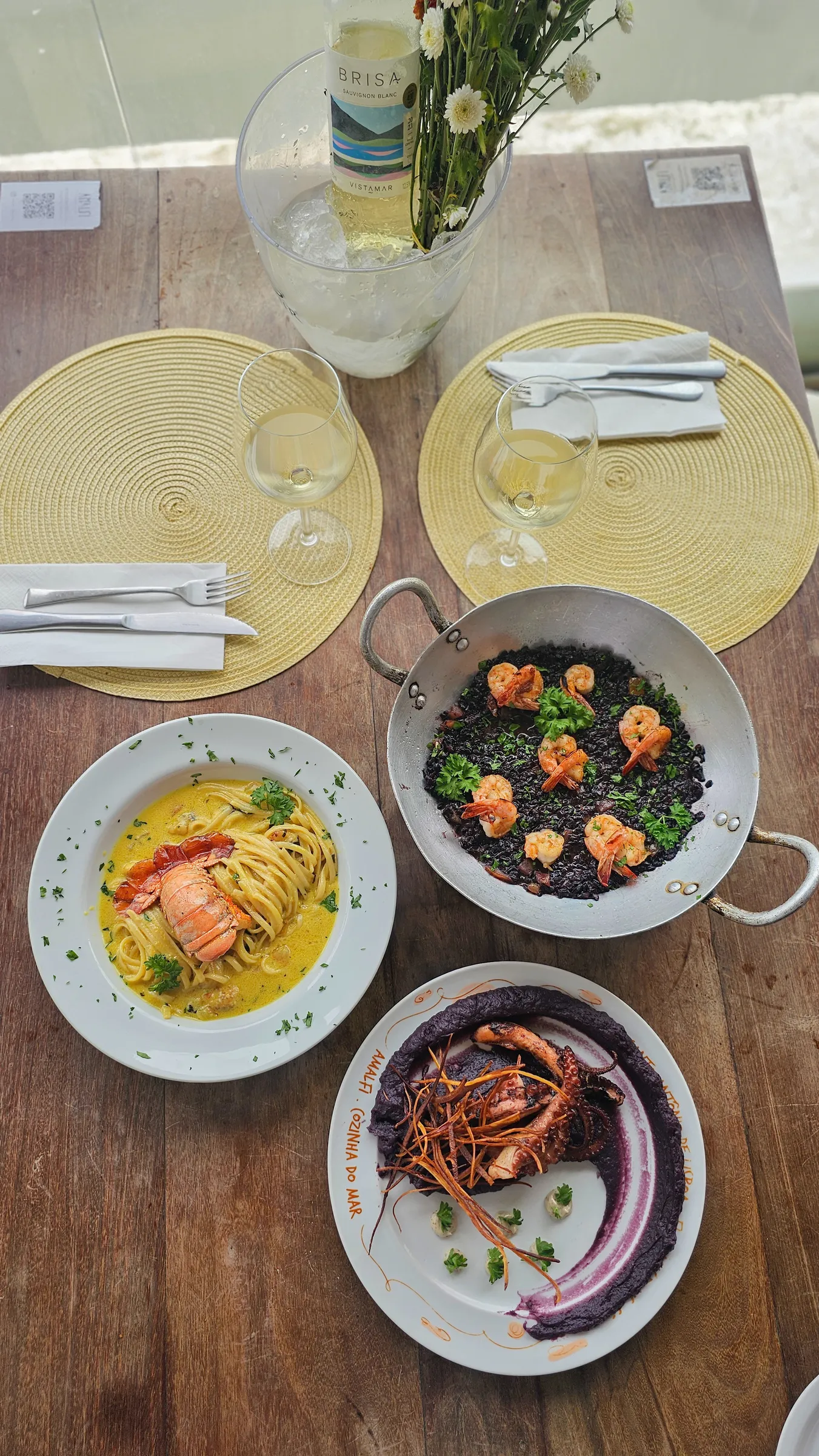 Mesa com pratos e vinho para celebração no Amalfi